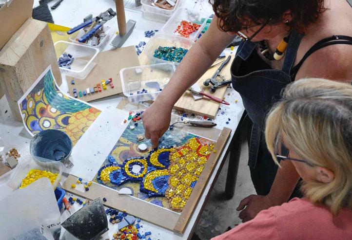 melaine lanoe et une stagiaire discutent devant une mosaique en cours inspiree de klimt